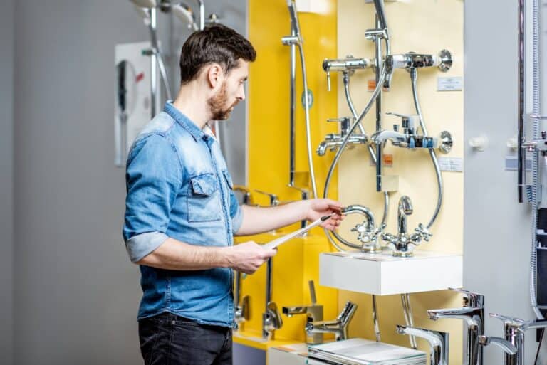 Man choosing shower faucet in the shop